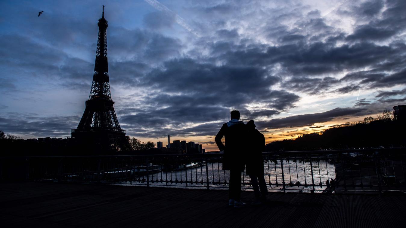 <p>Ein Paar steht auf der Debilly-Fußgängerbrücke an der Seine und betrachtet den Sonnenuntergang hinter dem Eifelturm.</p>