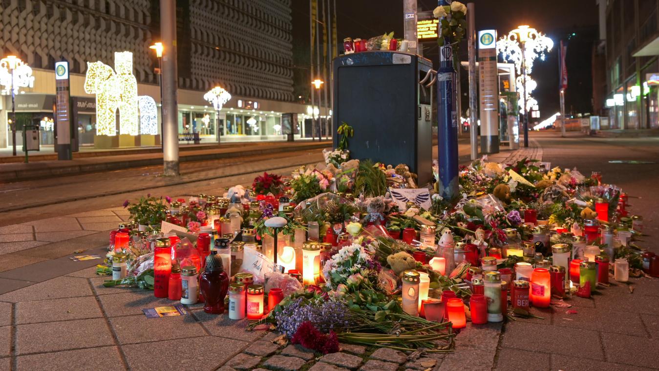 <p>Blumen und Kerzen stehen im Gedenken an die Anschlagsopfer an einer Straßenbahnhaltestelle in der Ernst-Reuter-Allee.</p>