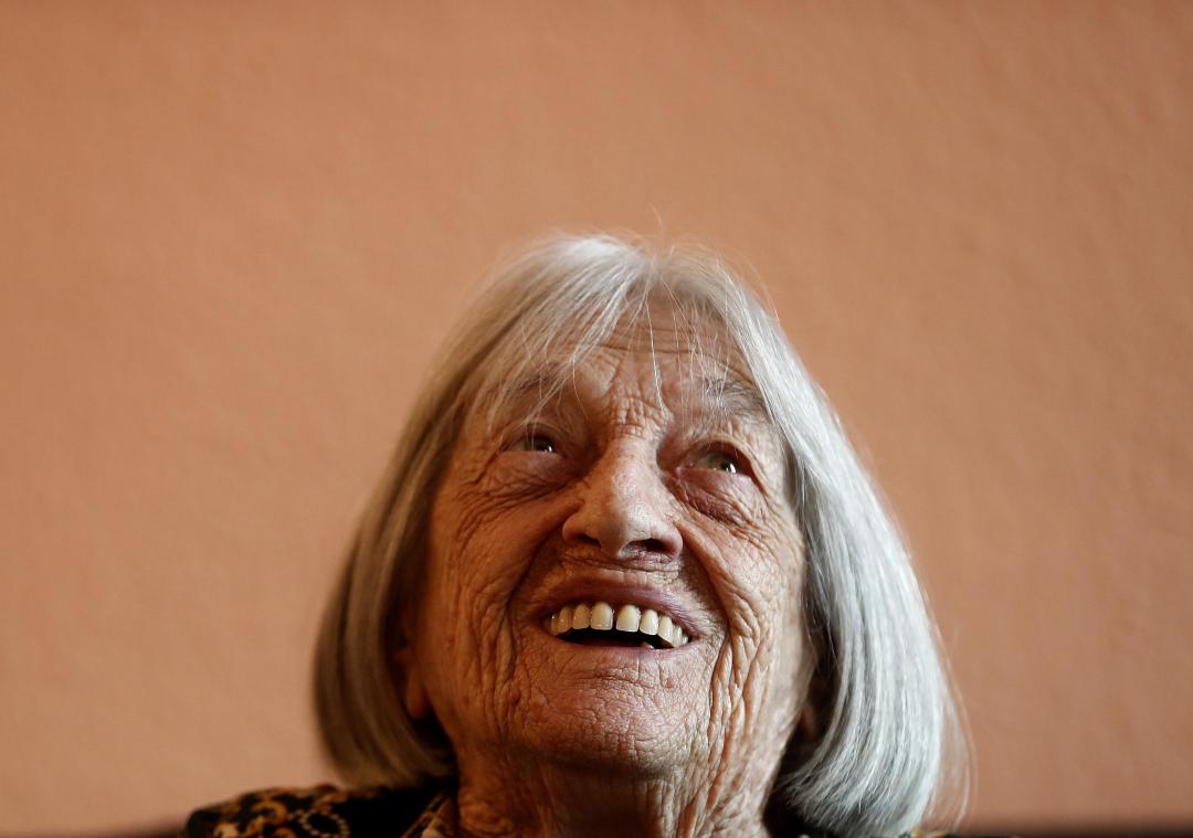 <p>Agnes Keleti, ehemalige olympische Goldmedaillengewinnerin im Turnen, lächelt in ihrer Wohnung.</p>