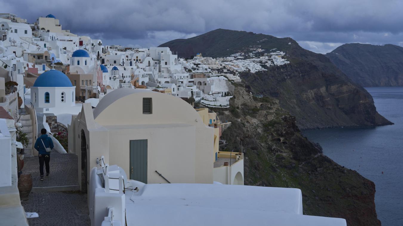 <p>Ein Tourist nähert sich einer orthodoxen Kirche mit blauer Kuppel in Oia auf der erdbebengeschädigten Insel Santorini.</p>