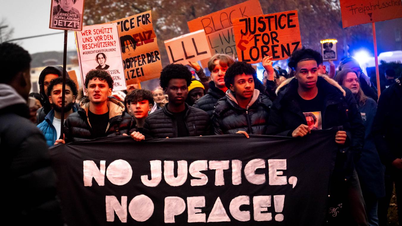 <p>Mehrere Hundert Menschen ziehen unter dem Motto „Gerechtigkeit für Lorenz“ nach den tödlichen Polizeischüssen auf einen 21-Jährigen hinter einem Transparent „No Justice, No Peace“ durch die Innenstadt.</p>