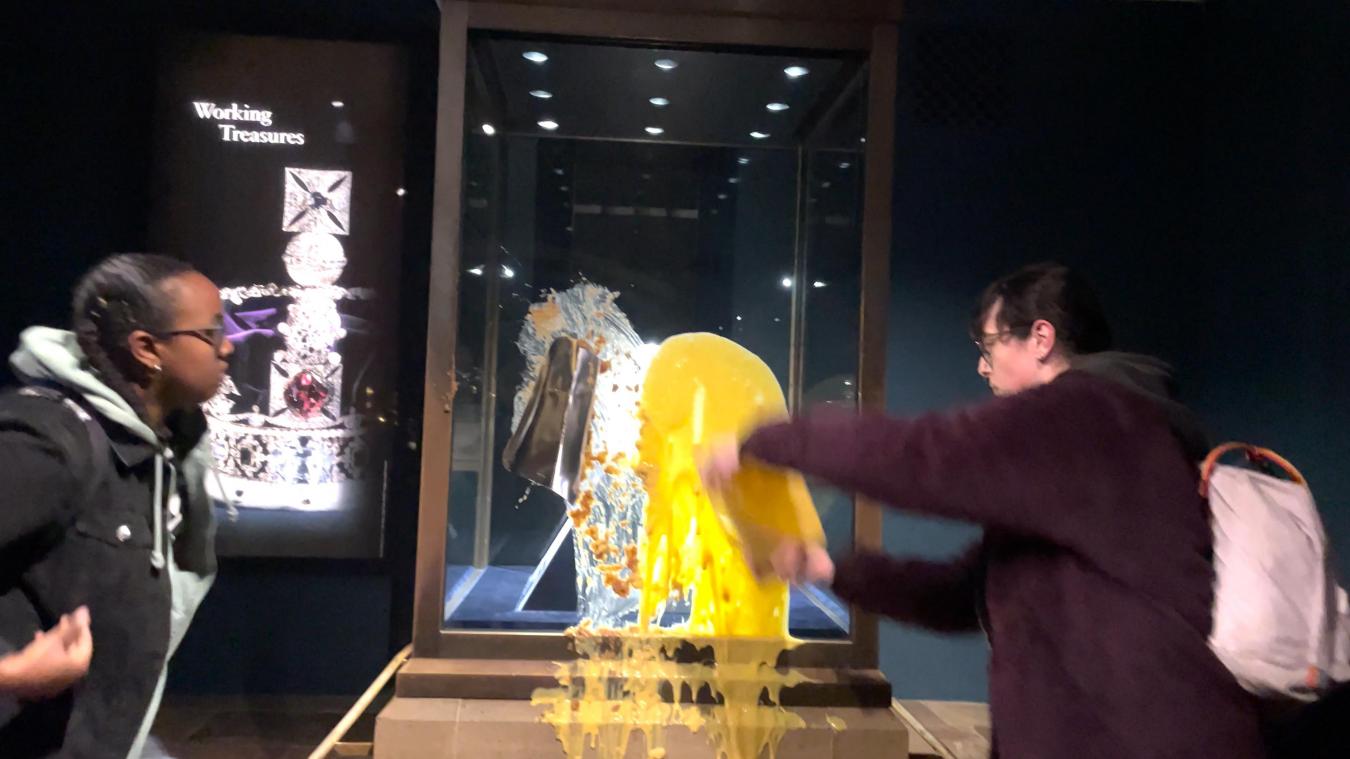 <p>Handout eines Video, das zwei Unterstützerinnen von „Take Back Power“ zeigt, die einen Nachtisch, mutmaßlich Apfel-Crumble und Vanillesoße, über die Kronjuwelen im Tower of London werfen.</p>