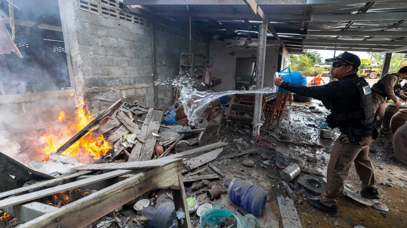 <p>Ein thailändischer Polizist verschüttet Wasser, um das Feuer in einem Haus einzudämmen, das nach Angaben der örtlichen thailändischen Sicherheitskräfte durch kambodschanische Artillerie in der thailändischen Provinz Surin beschädigt wurde.</p>