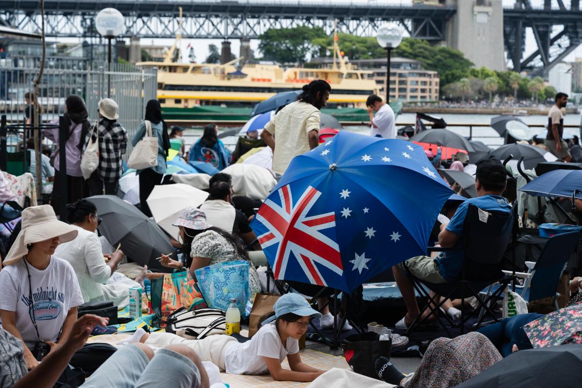 <p>Menschen halten sich vor den Silvesterfeierlichkeiten in der Nähe des Opernhauses in Sydney auf.</p>