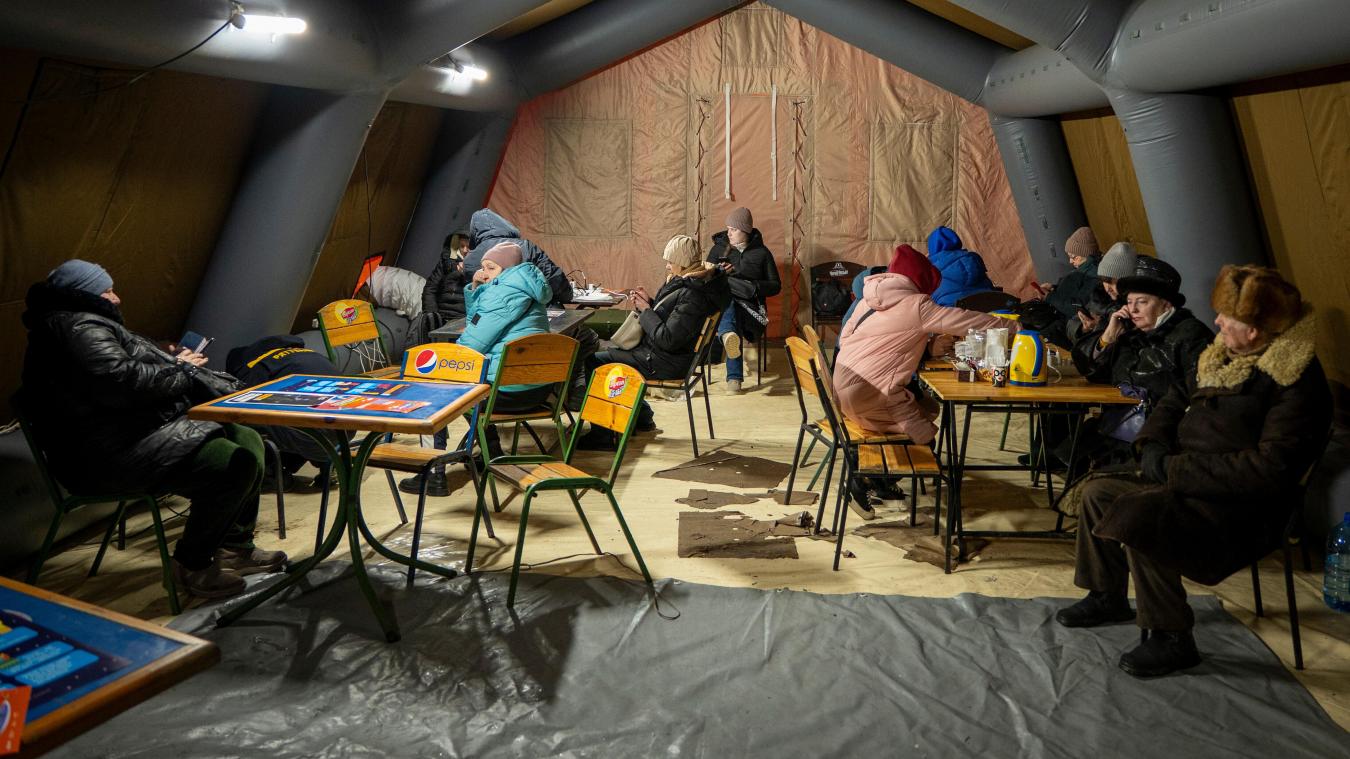 <p>Menschen wärmen sich und laden ihre Akkus in einem Zelt auf, das der Rettungsdienst nach den russischen Luftangriffen auf den ukrainischen Energiesektor aufgestellt hat.</p>