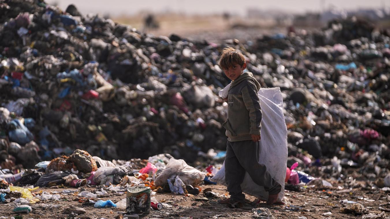 <p>Ein palästinensischer Junge schaut in die Kamera, während er auf einer Mülldeponie in Khan Younis im südlichen Gazastreifen Müll sortiert.</p>