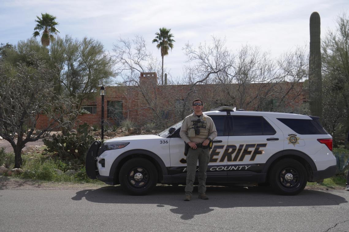 <p>Ein Angehöriger des Pima County Sheriff's Department steht neben seinem Fahrzeug vor dem Haus von Nancy Guthrie.</p>
