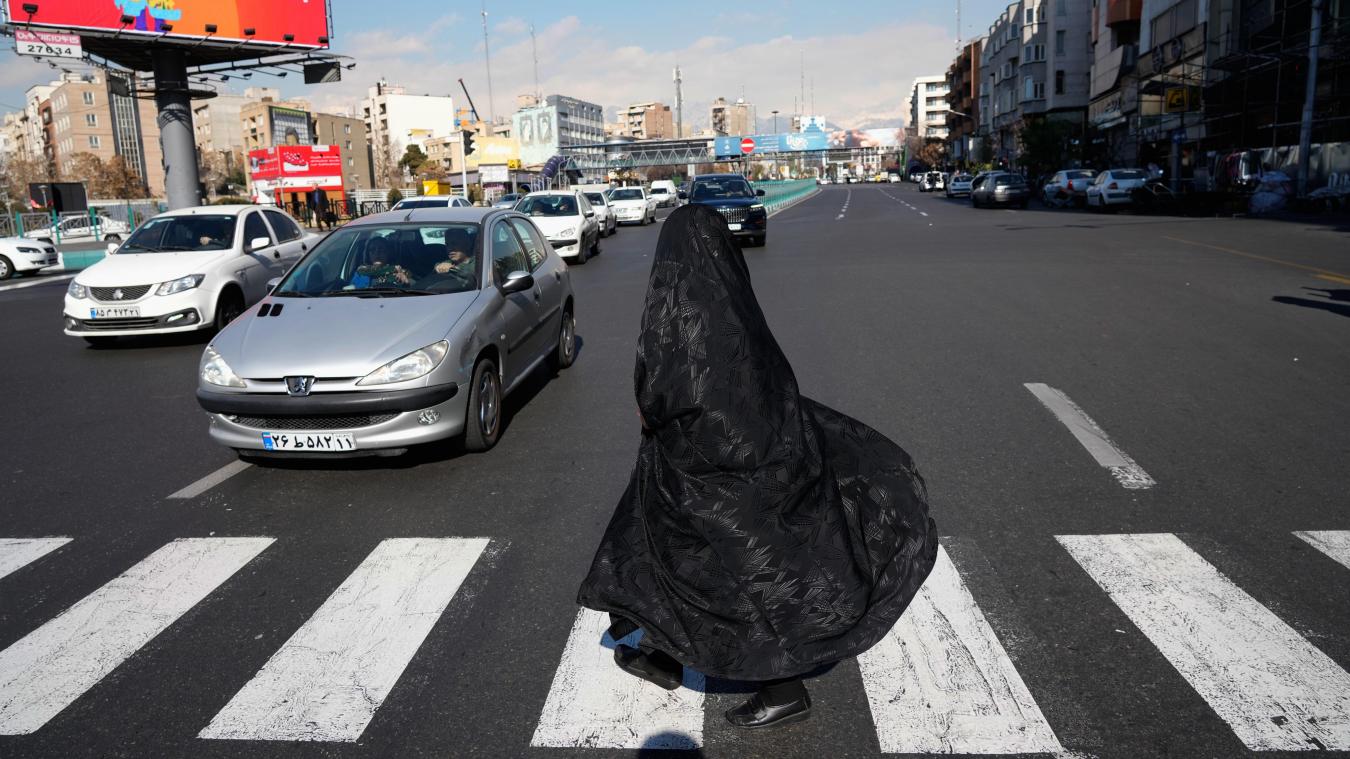 <p>Eine Frau überquert eine Kreuzung in der Innenstadt von Teheran.</p>