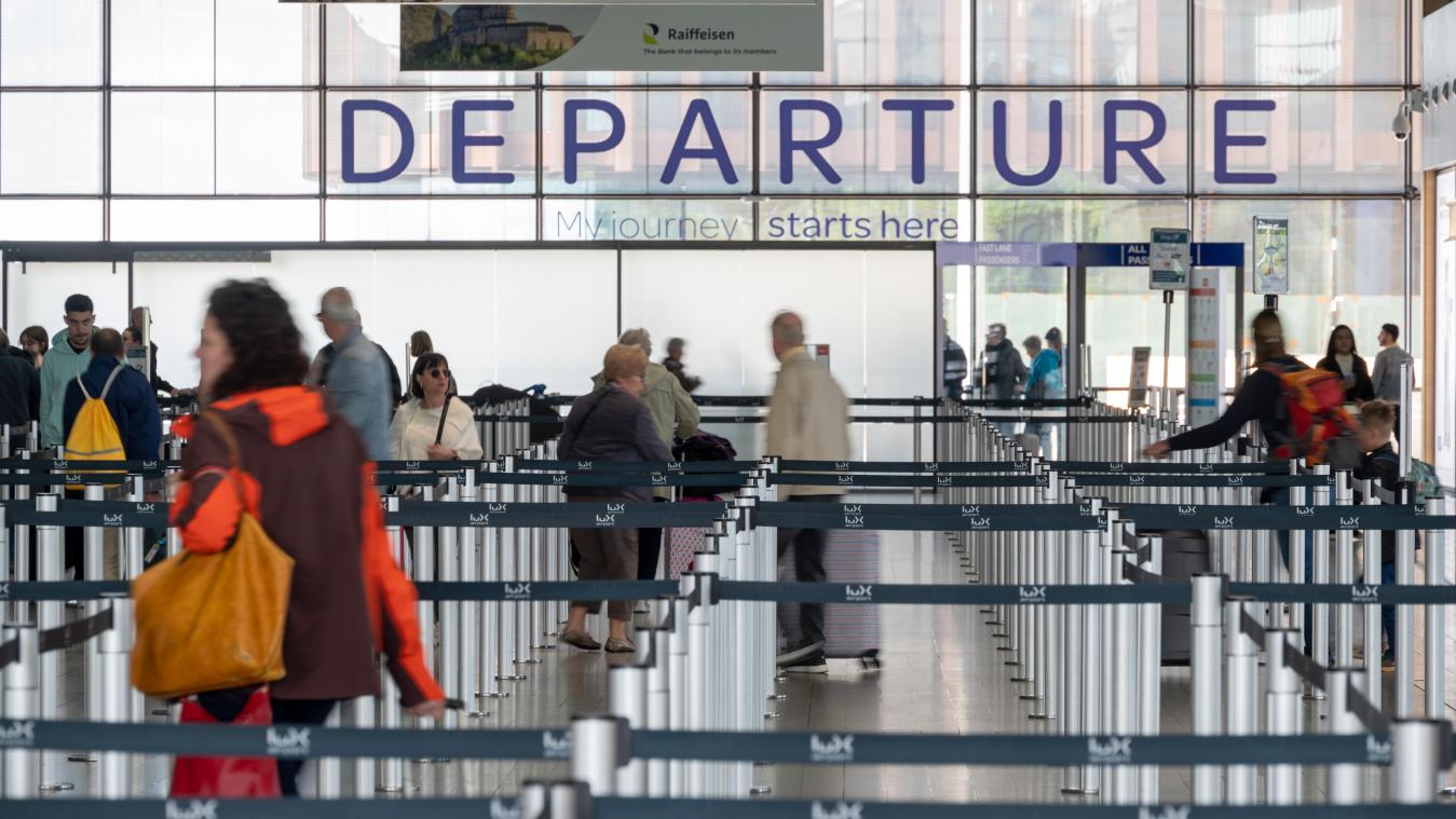 <p>Passagiere gehen mit ihrem Gepäck zu Abflugschaltern des Luxemburger Flughafens Findel.</p>