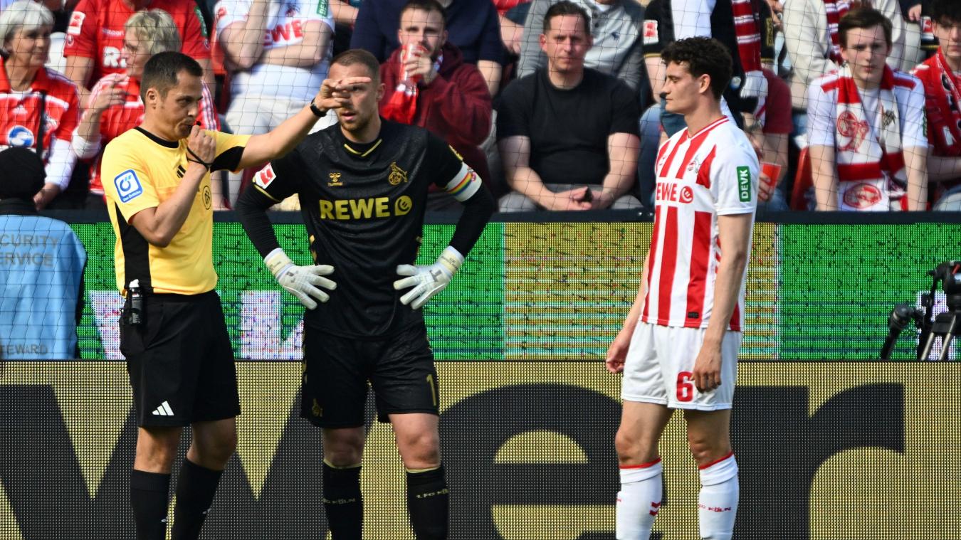 <p>Schiedsrichter Robert Hartmann zeigt nach der Video-Überprüfung auf den Elfmeterpunkt. Torwart Marvin Schwäbe und Eric Martel (beide 1. FC Köln) stehen dabei.</p>