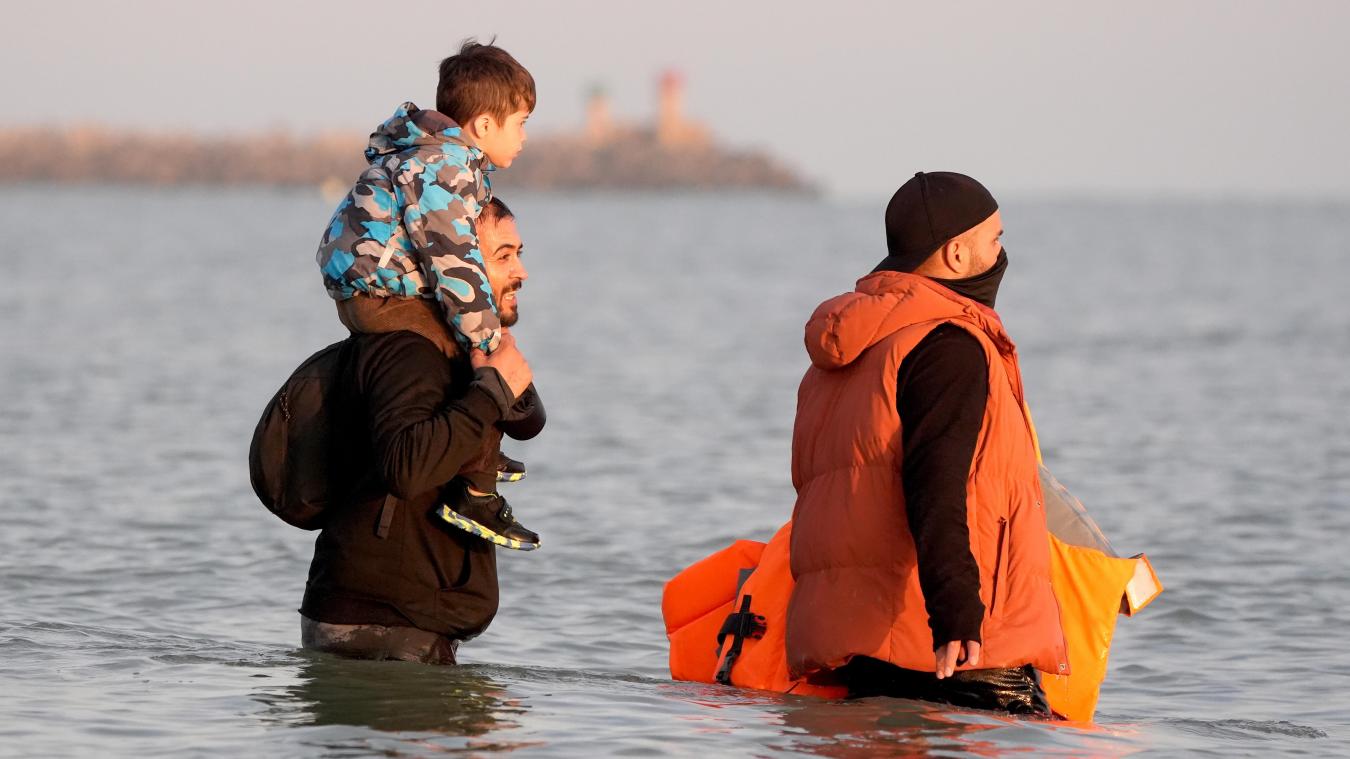 <p>Ein Mann und ein kleines Kind, vermutlich Migranten, waten ins Meer zu einem Schlauchboot, das sie über den Ärmelkanal nach Großbritannien bringen soll.</p>