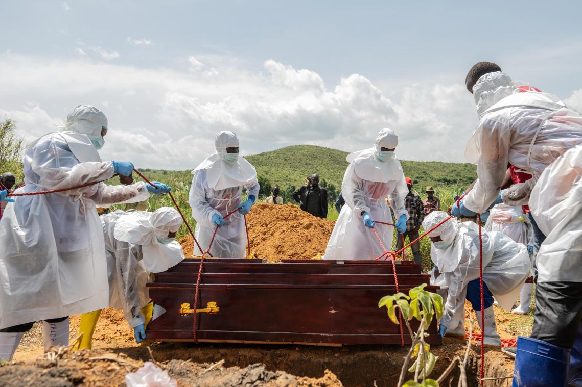 <p>Mitarbeiter des Roten Kreuzes beerdigen ein Ebola-Opfer auf dem Rwampara-Friedhof.</p>