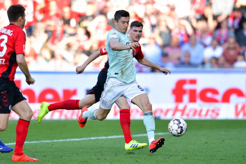 <p>Münchens Robert Lewandowski (vorne) und Freiburgs Pascal Stenzel kämpfen um den Ball.</p>