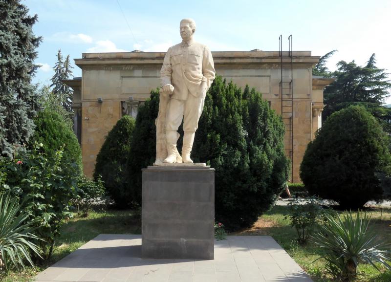 <p>Ein Denkmal von Stalin. Dahinter steht sein angebliches Geburtshaus, überdacht von einem Bau in stalinistischer Gotik.</p>