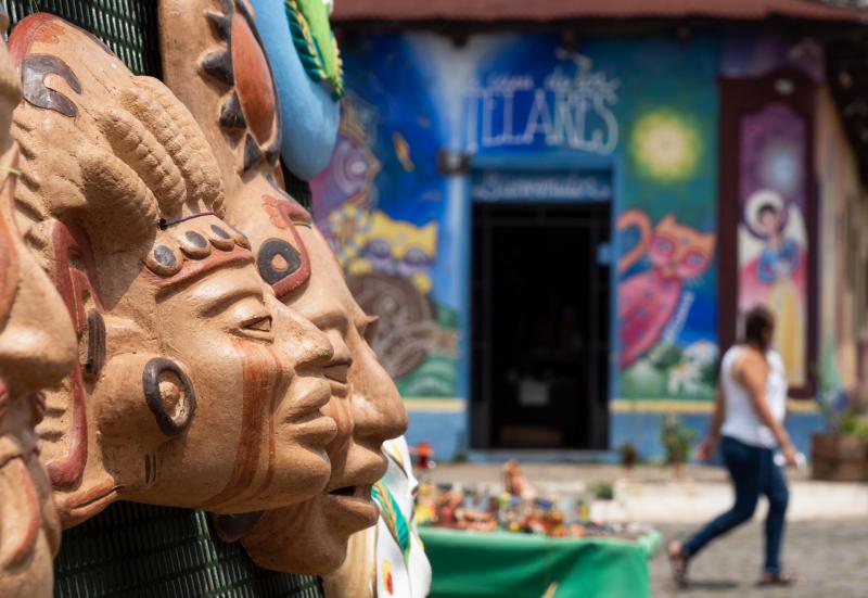 <p>Maskenverkauf in Ataco, im Hintergrund Wandmalereien - der Ort bietet Kreativen jeden Menge Raum.</p>