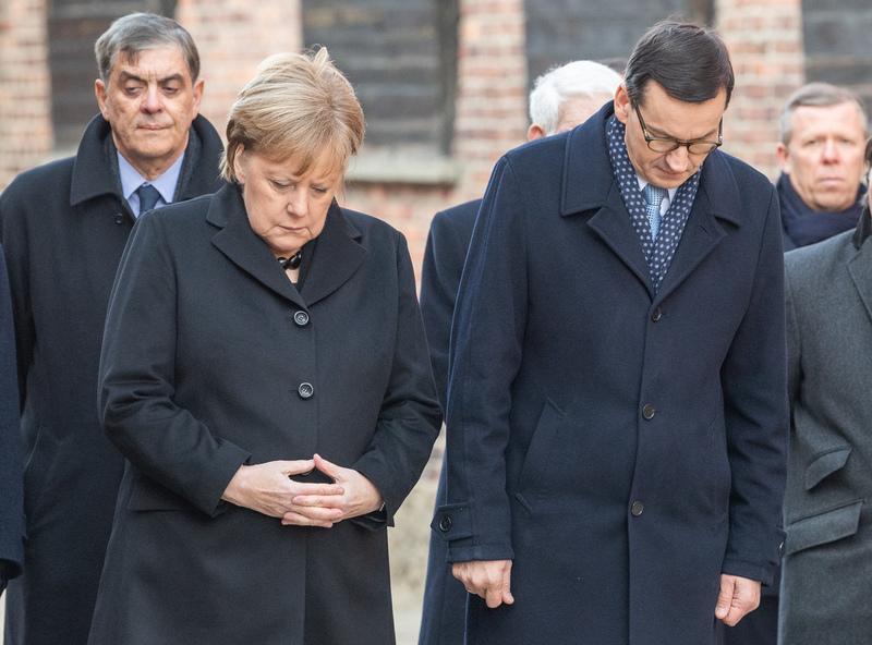 <p>Merkel und Morawiecki verneigen sich nach einer Kranzniederlegung an der Todesmauer im ehemaligen deutschen Konzentrationslager Auschwitz.</p>