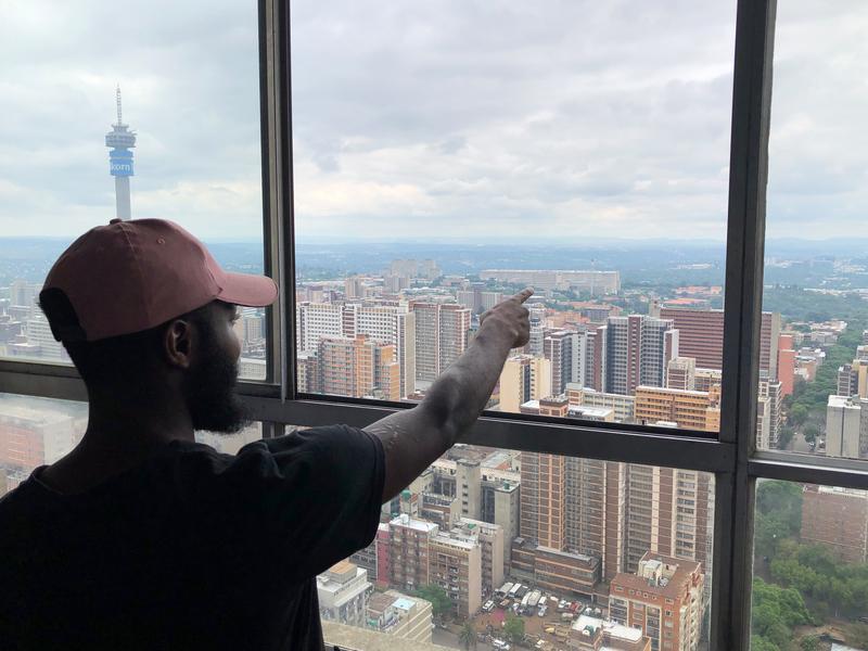 <p>Tourguide Gilbert Mwapé erläutert Besuchern von der 52. Etage des Ponte Towers aus Johannesburgs Stadtteile und deren Historie.</p>