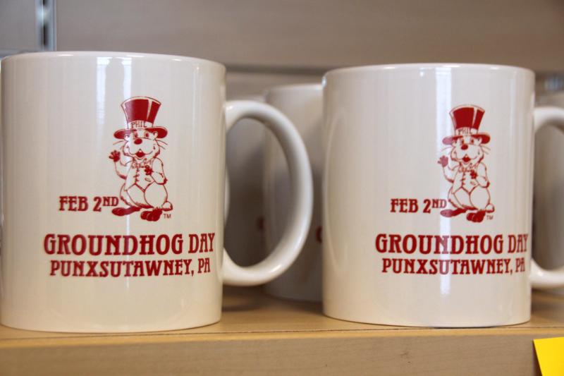 <p>Zwei Tassen mit einem aufgezeichneten Murmeltier und dem Schriftzug „Groundhog Day“ stehen auf einem Regalbrett.</p>