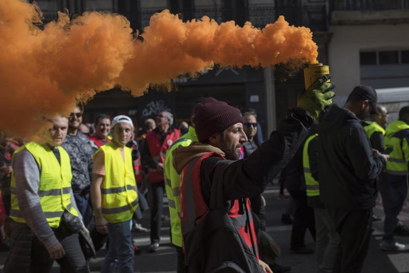 <p>Frankreich, Marseille: Ein streikender Hafenarbeiter hält eine Rauchfackel.</p>