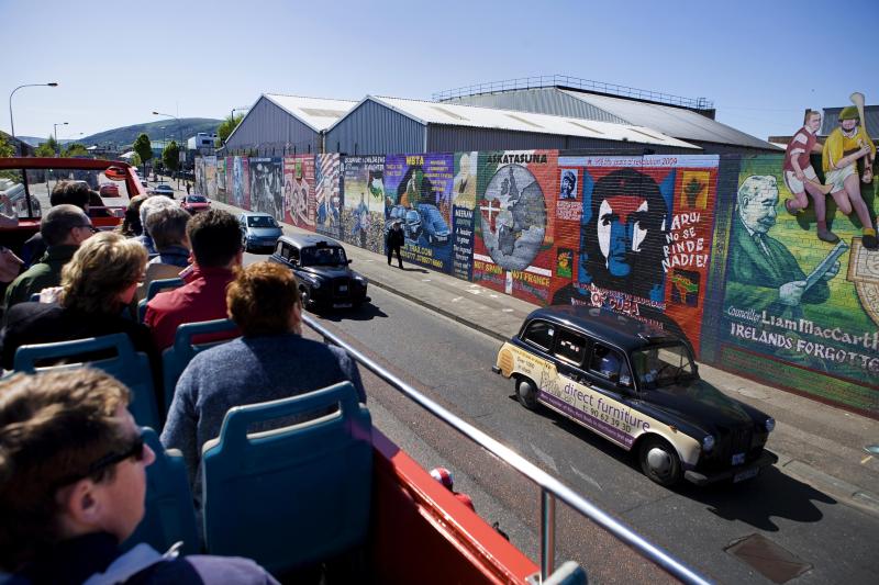 <p>Touristen auf Bustour in Belfast: Überall in der Stadt sind Graffiti mit politischen Botschaften zu sehen.</p>