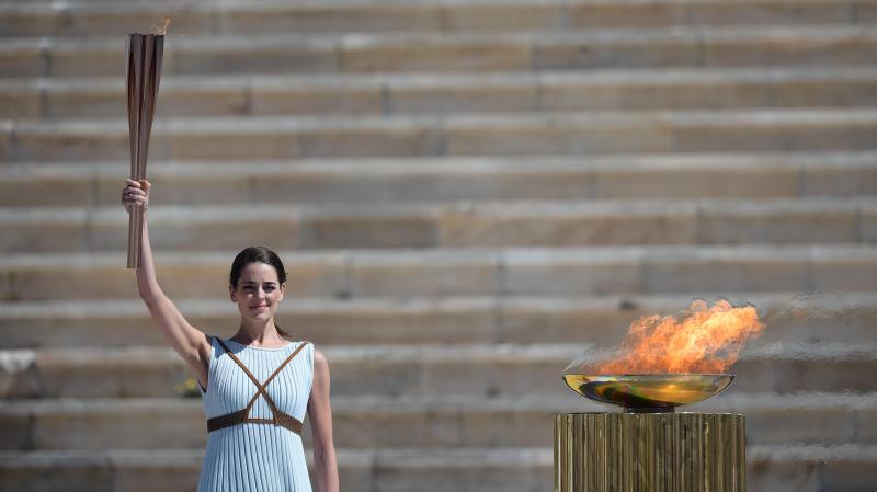 <p>Die als altgriechische Hohepriesterin verkleidete griechische Schauspielerin Xanthi Georgiou hält die olympische Fackel während der olympischen Flammenübergabezeremonie in Tokio am 19. März 2020 in Athen.</p>