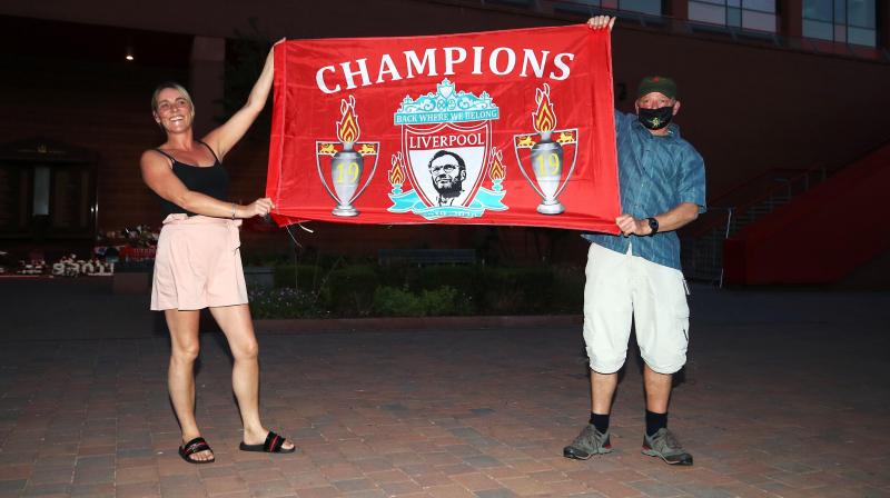 <p>Mit Mundschutz vor dem Stadion: Ausgerechnet in Zeiten des Coronavirus dürfen die Liverpool-Fans die langersehnte 19. Meisterschaft feiern.</p>