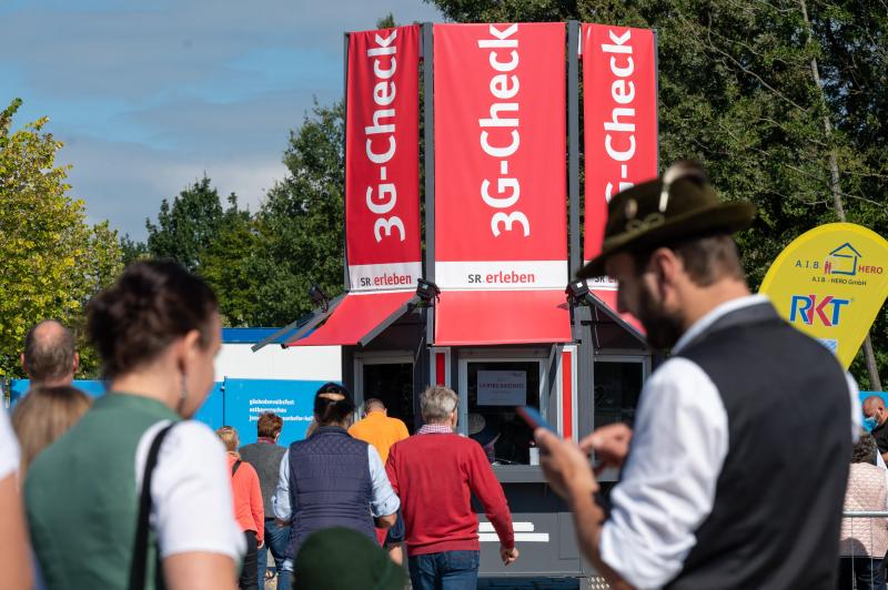 <p>Besucher stehen am 3G-Check vor dem Eingang zum Straubinger Herbstfest.</p>