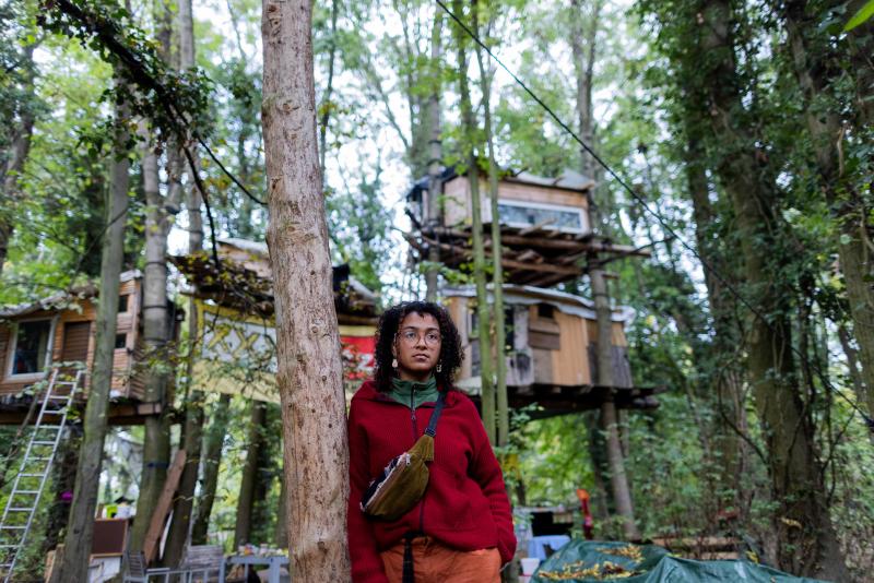 <p>Umweltaktivistin Amaka steht im Protestcamp vor Baumhäsuern Sie will bis zum Ende bleiben.</p>