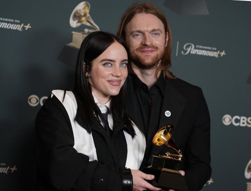 <p>Billie Eilish (l.) und Finneas posieren im Presseraum mit dem Preis für den Song des Jahres für „Wildflower“. Beide tragen einen Button mit der Aufschrift „ICE out“.</p>
