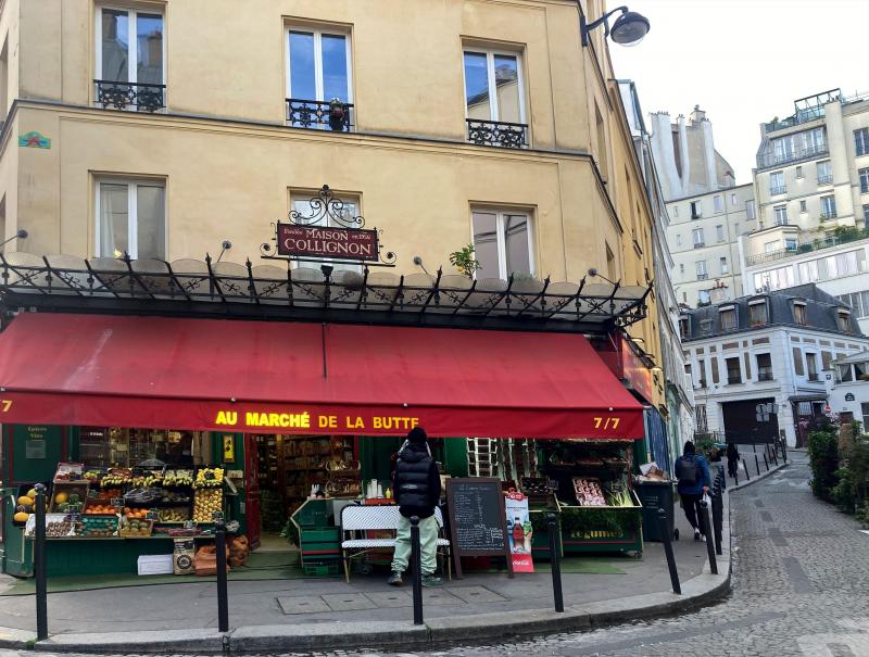 <p>Ein Plakat des Films ist im Fenster des Lebensmittelladens „Épicerie Collignon“ befestigt. Der Laden heißt in Wirklichkeit „Au Marché de la Butte“ und befindet sich an der Ecke 56 Rue des Trois Frères und Rue Androuet im Pariser Viertel Montmartre.</p>