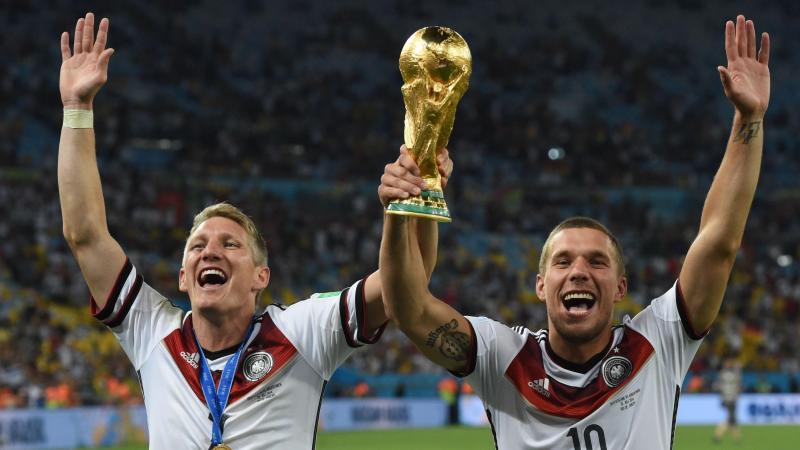 <p>Bastian Schweinsteiger (l.) und Lukas Podolski jubeln nach dem Sieg der FIFA Weltmeisterschaft 2014 mit dem Pokal.</p>