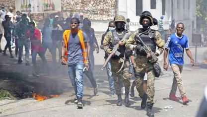 <p>Polizisten gehen zwischen Demonstranten während eines Protestes gegen die Ermordung des haitianischen Präsidenten Moïse in der Nähe der Polizeistation von Petion Ville.</p>