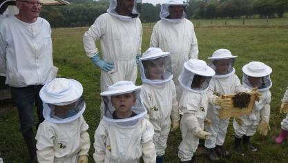 <p>Mit Anzug, Imkerhut und Handschuhen geschützt machen die Kinder praktische Erfahrungen mit den Bienen.</p>