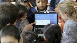 <p>Kinder blicken mit einem Erzieher auf einen Computer mit Wetternachrichten. Nach einem Modellprojekt in landesweit zwölf Kitas sollen die Erfahrungen mit digitaler Erziehung in Kindertagesstätten analysiert und die Ergebnisse zur Verfügung gestellt werden.</p>