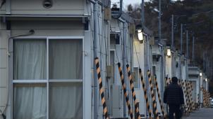 <p>Eine Person geht an temporären Fertigbauwohnungen vorbei. Iwaki, Präfektur Fukushima, gehört zu einer Region, die vom Erdbeben am 11. März 2011 und dem Tsunami im Nordosten Japans betroffen ist.</p>