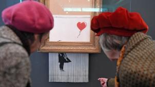 <p>Besucher betrachten das geschredderte Banksy-Bild Love is in the Bin im Museum Frieder Burda.</p>