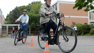 <p>Kursteilnehmer fahren mit ihrem Elektrofahrrad, einem Pedelec, durch einen Parcours.</p>