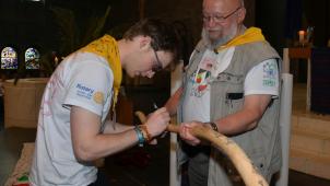 <p>Nicolas Eicher graviert das Datum der Rückkehr im Pilgerstab, den Willy Margraff in den Händen hält, ein.</p>