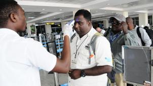 <p>Amtsärzte messen die Körpertemperatur von Passagieren am Flughafen Entebbe.</p>