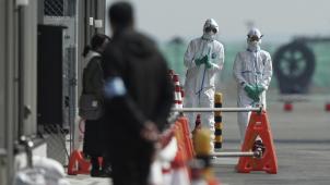 <p>Beamte in Schutzanzügen stehen in der Nähe des Kreuzfahrtschiffs „Diamond Princess“ im Hafen von Yokohama. An Bord des unter Quarantäne gestellten Kreuzfahrtschiffes in Japan sind weitere 41 Fälle des neuen Coronavirus festgestellt worden.</p>