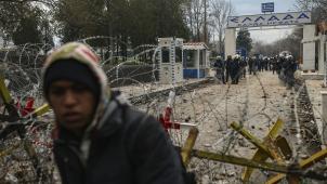 <p>Griechische Polizisten bewachen die Grenze zu Griechenland während ein Migrant vor dem Grenzübergang steht. Griechenland wird weiter die Grenze Europas zur Türkei verstärkt überwachen und illegale Einreisen in die EU verbieten.</p>