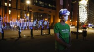 <p>Ein Greenpeace-Aktivist vor dem Hologramm in Brüssel</p>
