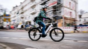 <p>Eine Frau ist mit einem Elektrofahrrad unterwegs.</p>