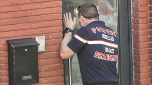 <p>Ein Mitglied der Feuerwehr überprüft in Lüttich, ob sich in einem Haus Menschen befinden.</p>