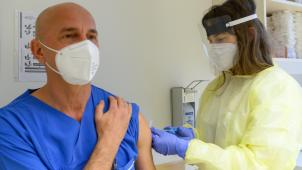 <p>Ein Krankenpfleger in der Notaufnahme wird gegen Corona geimpft.</p>