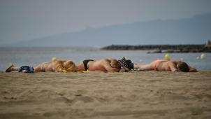 <p>Touristen sonnen sich am Strand La Playa de Las Vistas im Süden der Kanaren-Insel.</p>