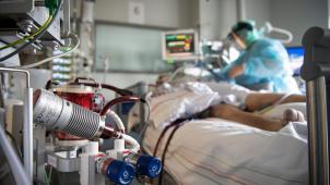 <p>Ein schwer an Corona erkrankter Patienten wird auf der Intensivstation versorgt. Im Vordergrund steht eine ECMO-Maschine, an die der Mann angeschlossen ist.</p>