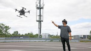 <p>Mohamed Azzahhafi steuert die Drohne DJI Matrice 210 RTK vor einem Mobilfunkmast.</p>