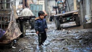 <p>Ein palästinensischer Junge geht bei regnerischem und kaltem Wetter in Gaza-Stadt vor dem Haus seiner Familie spazieren.</p>