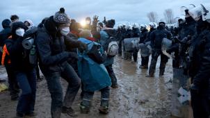 <p>Polizisten und Demonstranten stehen sich bei der Demonstration von Klimaaktivisten am Rande des Braunkohletagebaus bei Lützerath gegenüber.</p>